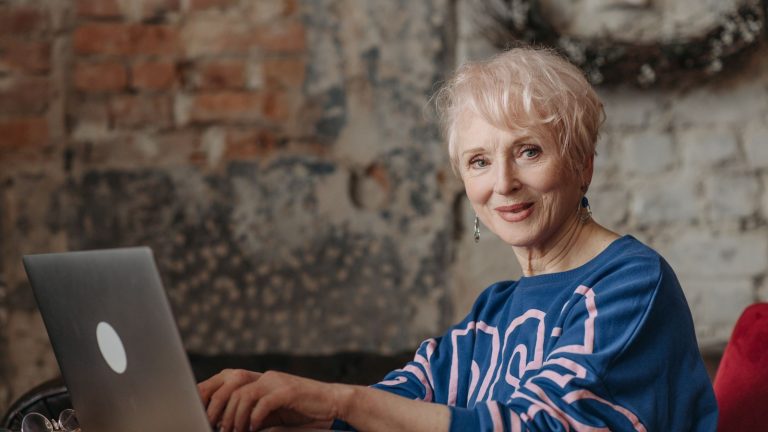 Starija žena koristi prijenosno računalo u kućnom uredu