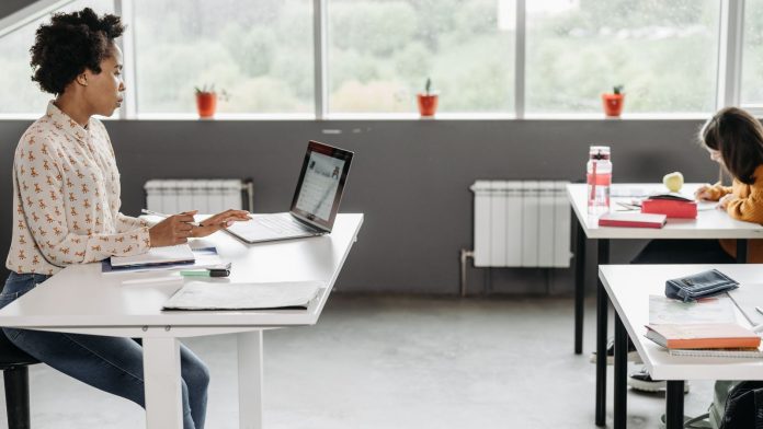 Stock | Nastavnica priprema nastavu na laptopu Nastavnica radi na prijenosnom računalu za stolom u učionici