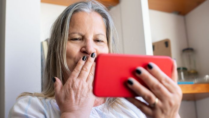 Stock | Starija žena koristi mobitel kod kuće Starija žena drži pametni telefon i razgovara u kućnom prostoru